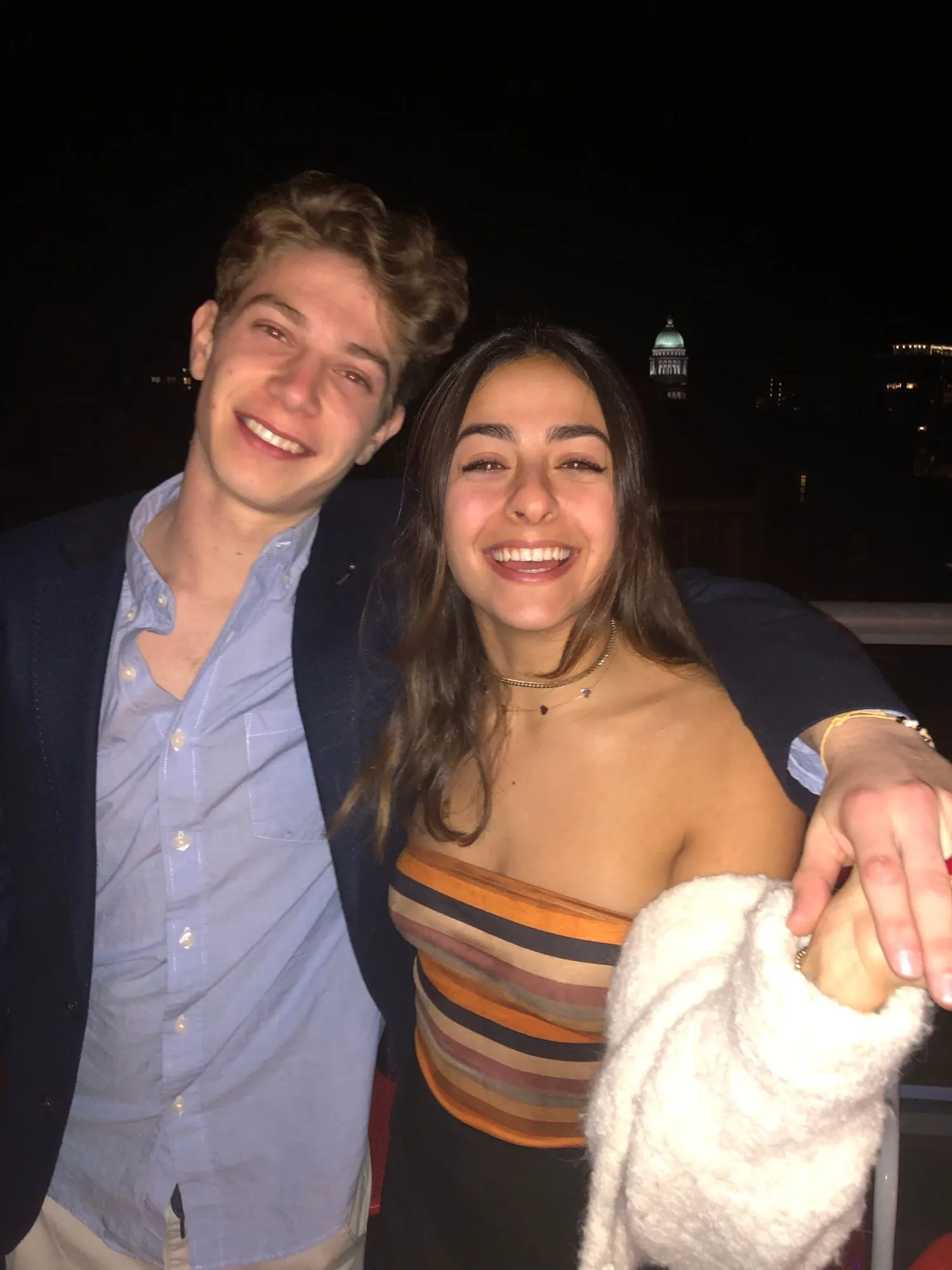 Lauren and Ben outside at night, leaning into each other