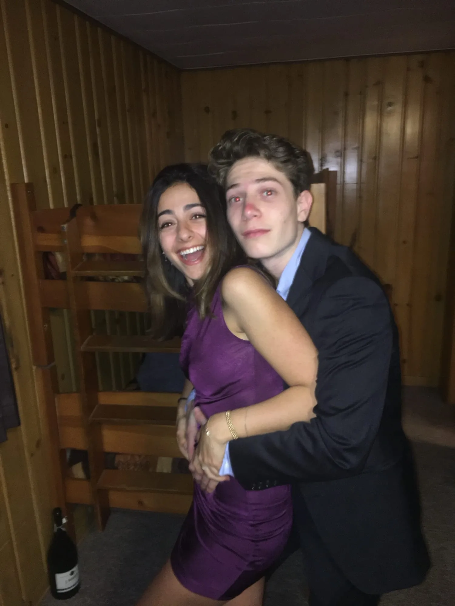 Lauren in a purple dress hugging Ben on a wooden porch