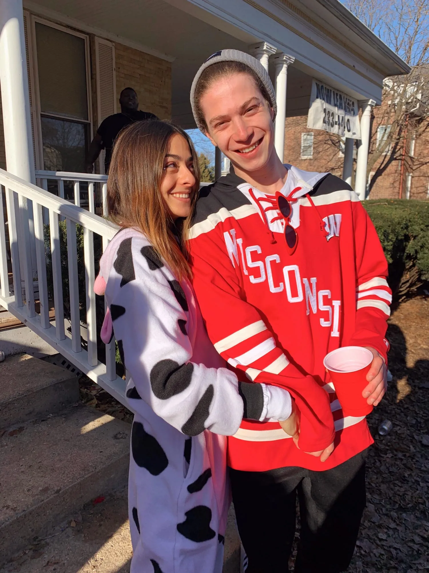 Lauren in a cow-print onesie beside Ben in a Wisconsin jersey