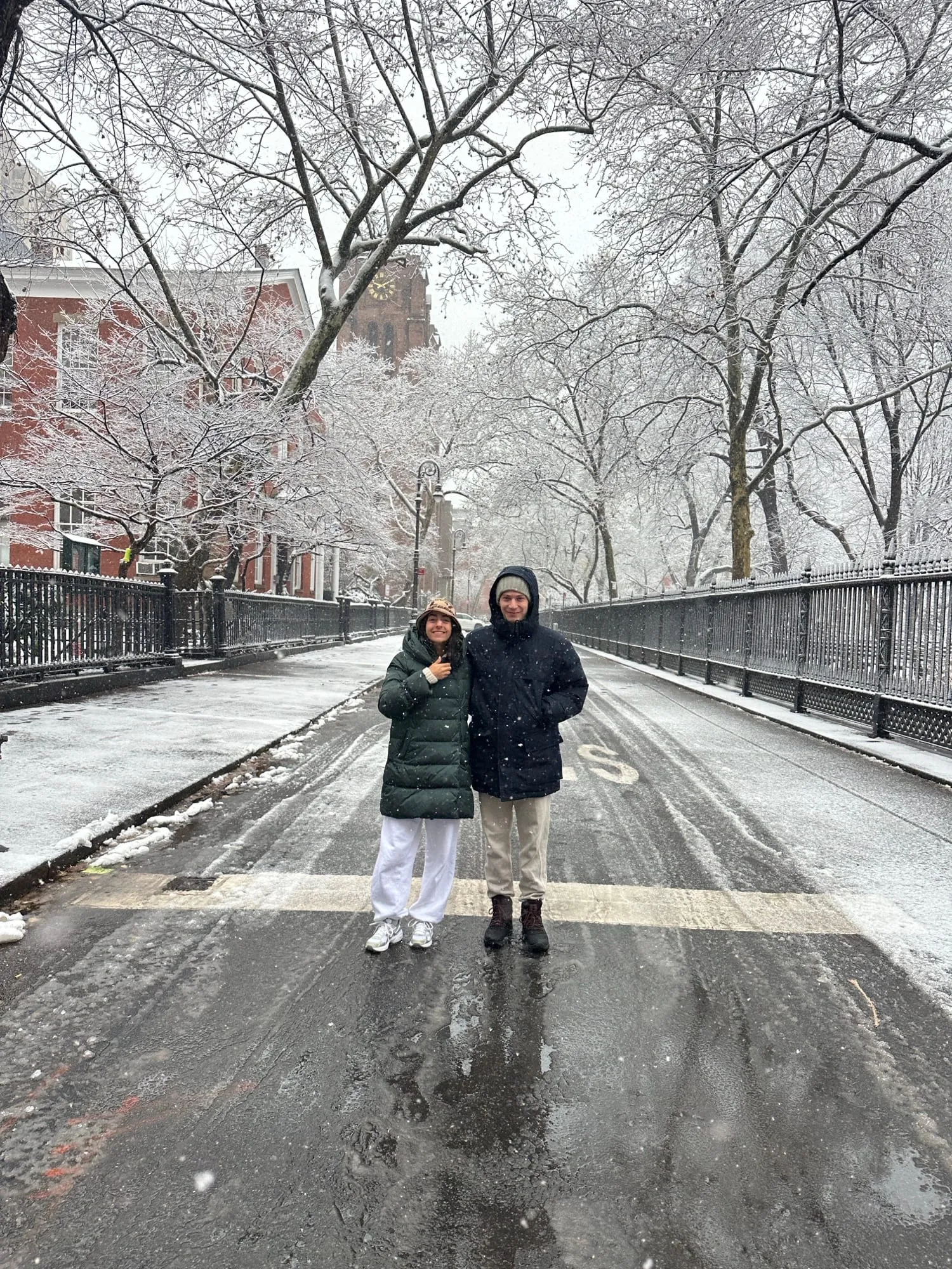 Lauren and Ben far down a snowy tree-lined path in the park