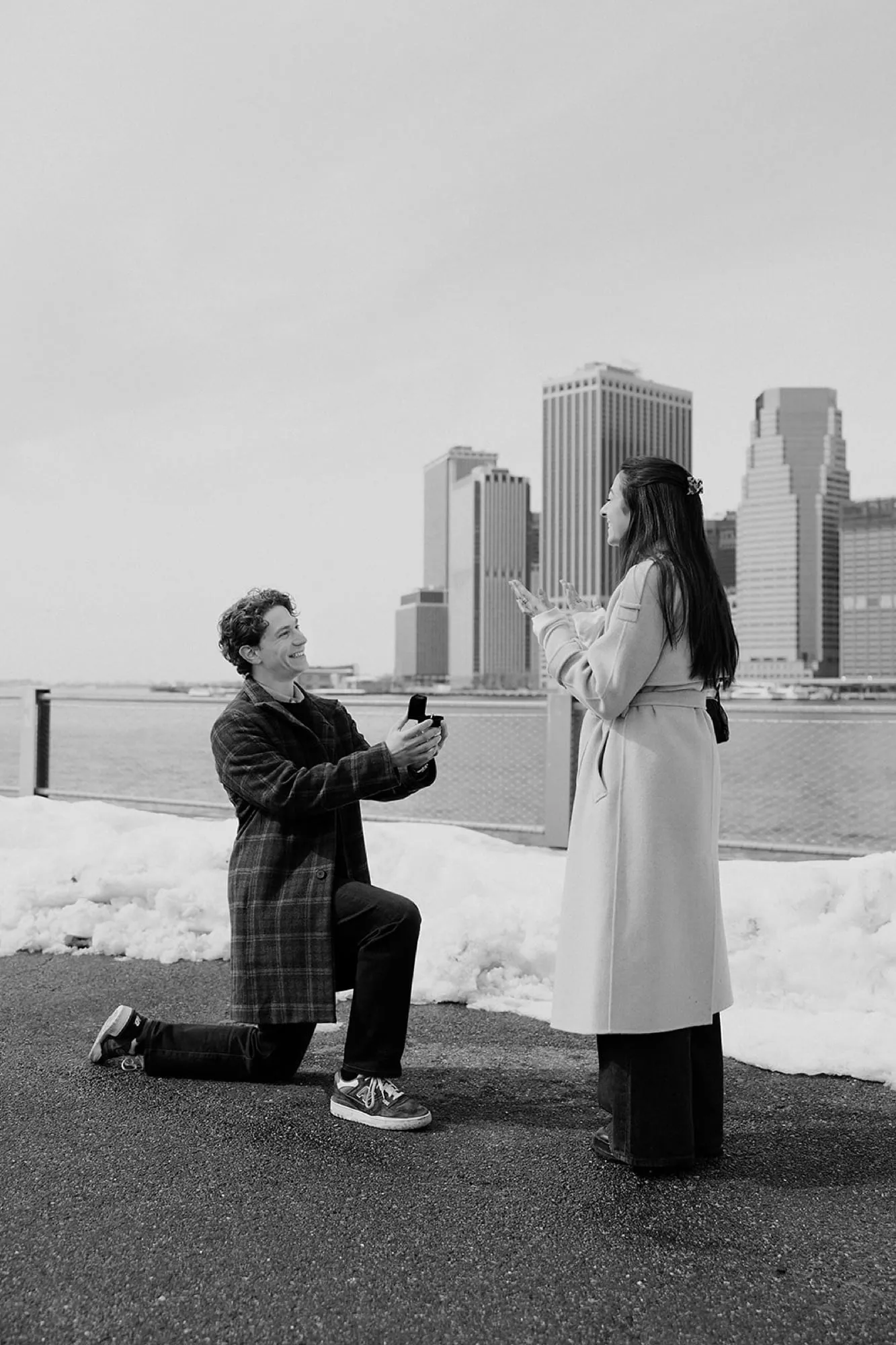 Black and white — Ben on one knee proposing, the skyline behind them